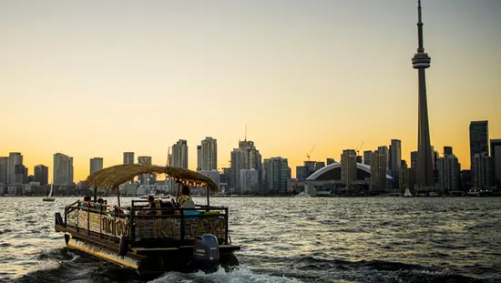 A boat taxi heads towards Toronto’s Harbourfront at dusk.